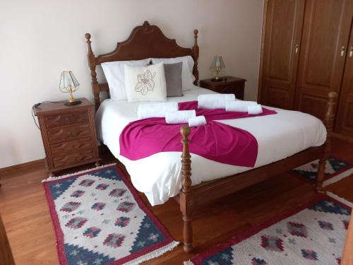Rio CaldoCasa de S Bento的一间卧室配有一张大床,铺有粉色和白色的床单。