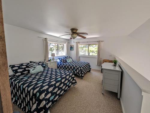 Prospect HarborSunset Cove Cottage private beach的一间卧室配有两张床和吊扇