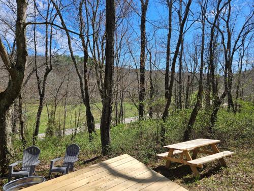 洛根Black Oak Campsite at Hocking Vacations Campsites - Tent not Included的树林里设有两把椅子和一张木餐桌
