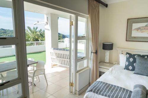 爱德华港Villa 43, The Estuary Country Estate, Port Edward, KZN South Coast的一间卧室设有一张床和一个阳台