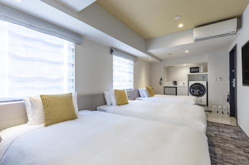 东京水道桥托克宇寄宿酒店的一间卧室设有三张床和窗户。