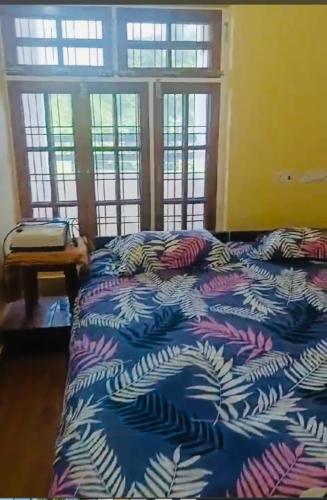 勒克瑙Pretty park facing 2 bedroom guesthouse near lohia park Gomtinagar的窗户客房内的一张带蓝色棉被的床