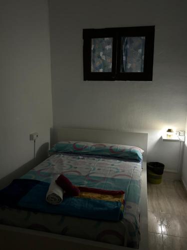 巴塞罗那SAN Rafael的卧室内的一张床铺,墙上设有两个窗户