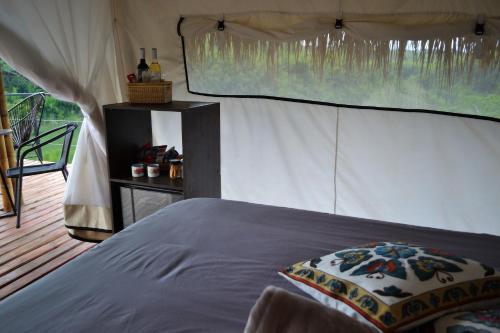 金巴亚Encanto Toscano的一间卧室配有一张床和一个帐篷