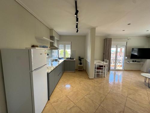 萨兰达Garden Villa Apartments的厨房配有白色冰箱和桌子