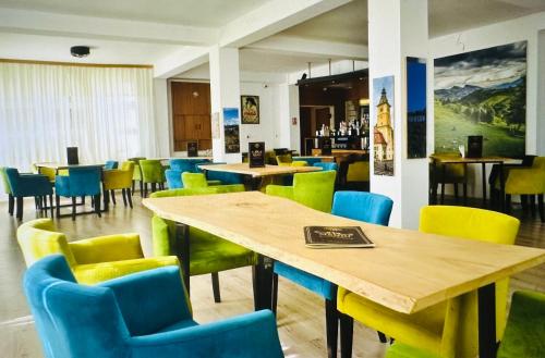 波亚纳布拉索夫Casa Verde Poiana Brasov的用餐室配有桌椅和黄色及蓝色的椅子