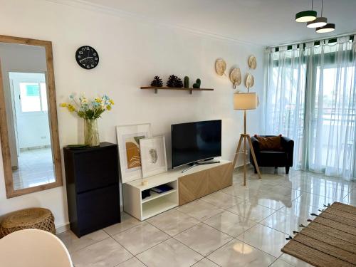 马斯帕洛马斯Las Olas DM cozy 2-bedrooms apartment的一间客厅,客厅的白色墙壁上配有电视