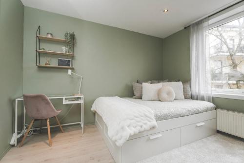 奥斯陆Newly renovated studio apartment at Frogner的一间卧室配有一张带窗户的床和一张书桌