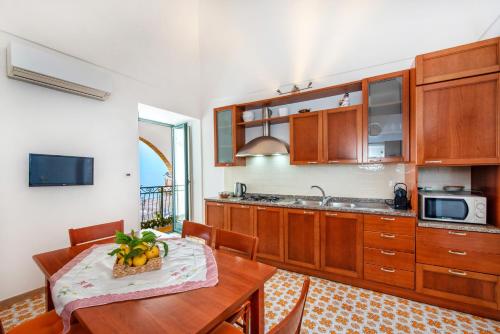 阿特拉尼若萨莉亚度假屋的厨房配有木制橱柜和1张带水果碗的桌子