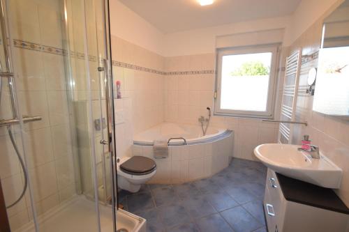 马格德堡Bliss Place - 1R Premium Apartment - Kingsize Bett, Smart TV, Küche, Balkon, Waschkeller的带浴缸、卫生间和盥洗盆的浴室