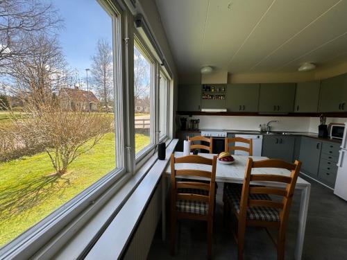 ÄlvseredFamily Friendly Villa Close To Ullared, 3bedrooms的厨房设有桌子和椅子,毗邻窗户