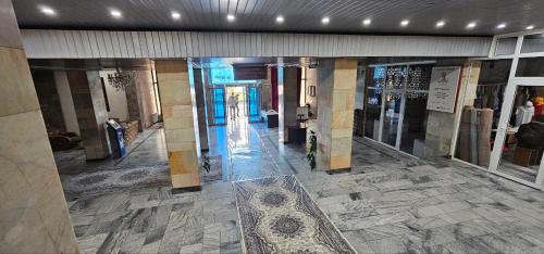 杜尚别Dushanbe Hotel的建筑里空的走廊,铺着瓷砖地板