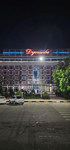 杜尚别Dushanbe Hotel的一座大建筑,晚上有标志