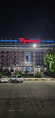 杜尚别Dushanbe Hotel的夜间在停车场停车的酒店
