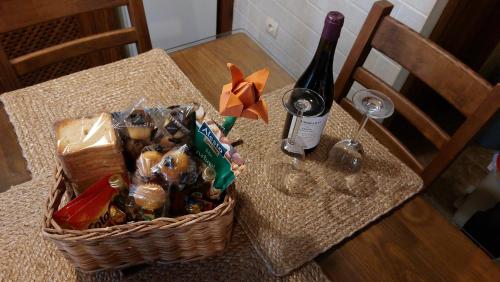 拉伊鲁埃拉El Tinao de la Hiruela (Entremelojos)的桌上的食品篮和一瓶葡萄酒