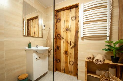 萨诺克Domek u Borsuka的一间带水槽和木墙的浴室