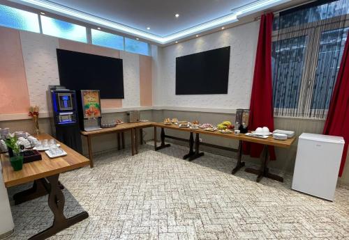科尔普Hôtel Elaïa的一间会议室,配有两张桌子和电视