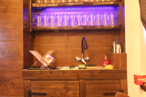 PorubaRefresh Club wellness的厨房配有水槽和带玻璃杯的架子