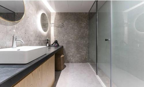 仁川市Hotel Lounge 7的一间带水槽和玻璃淋浴的浴室