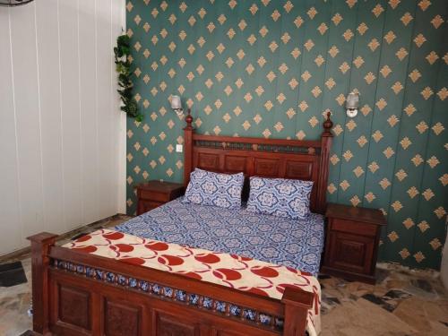 穆扎法拉巴德Kashmir Cottage Muzaffarabad的一间卧室设有一张木床和绿色的墙壁