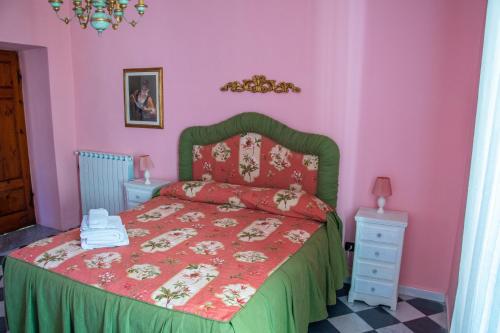 皮耶韦福斯切纳贝维德雷别墅酒店的一间卧室配有一张粉红色墙壁的床