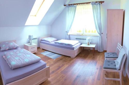 凯尔采Polna Zagroda - domek do wynajęcia的一间卧室设有两张床和窗户。