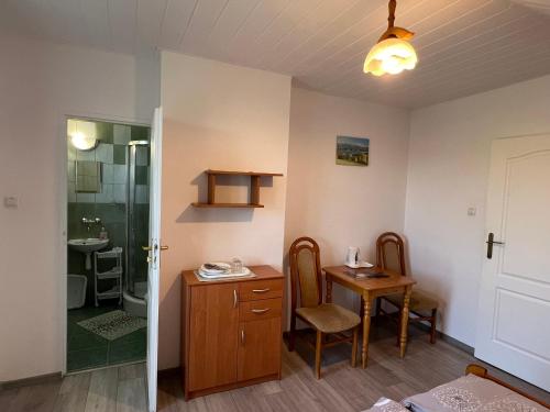 波拉齐克Nad Bieszczadzkim Morzem的客房设有桌子和带淋浴的浴室。