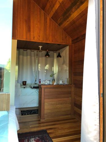 蒙特韦尔迪Chalé Sonho Diniz 2的客房设有带木墙和天花板的厨房。