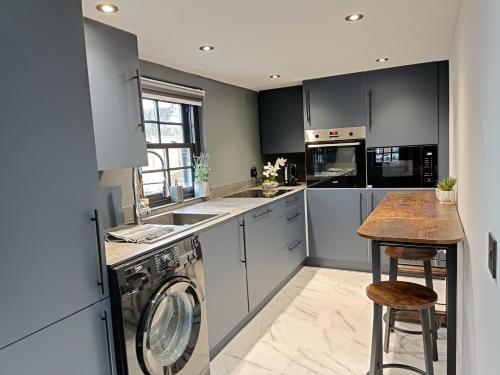 彼索普斯托福Stansted Airport Cottage的厨房配有洗衣机和烘干机
