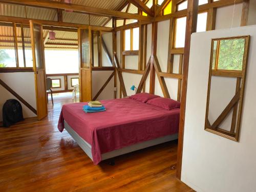 卡诺阿Jardin Pacifico的铺有木地板的客房内设有一间卧室和一张床。