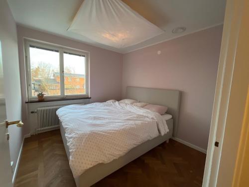 利丁厄Lidingö的卧室配有白色的床和窗户