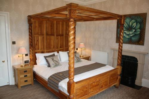 拉科克The Rectory Lacock - Boutique Bed and Breakfast的卧室配有一张木天蓬床和两盏灯