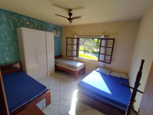 乌巴图巴CASA PRUMIRIM的一间卧室设有两张床和窗户。