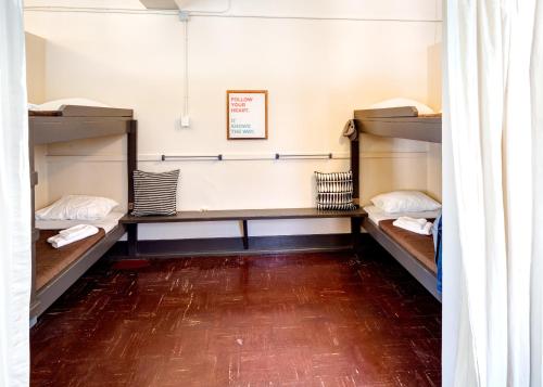 温哥华HI Vancouver Jericho Beach - Hostel的客房设有三张双层床,铺有木地板。