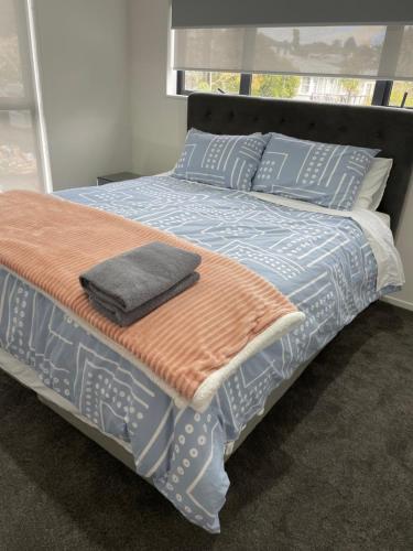奥克兰11 A Addison street home stay - room 2的一张配有蓝色和橙色床单和枕头的床