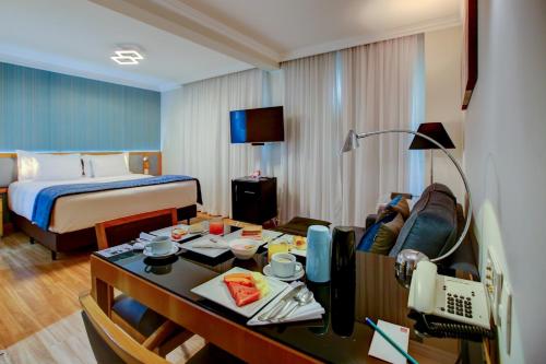 圣保罗Quality Suítes Oscar Freire的配有一张床和一张书桌的酒店客房