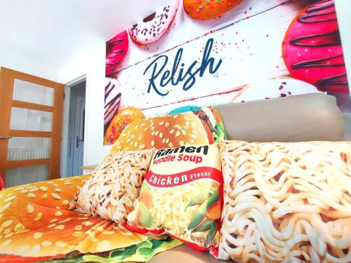 拉格斯The Relish - ground floor flat in Largs的一张带两个枕头的床和一盒丽思三明治小吃