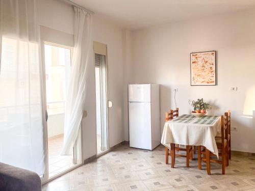 都拉斯LunaSol seaside Apartments的厨房配有桌子和冰箱