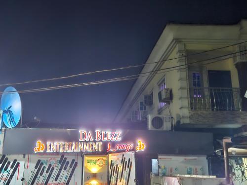 拉各斯Dablezz entertainment Lounge and Rooms的夜间在建筑物前的标志