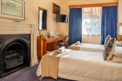 MiddelburgKaroo Country Inn的酒店客房设有两张床和壁炉