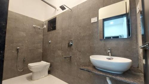 BhogweSea Majesty beach resort的一间带水槽、卫生间和镜子的浴室