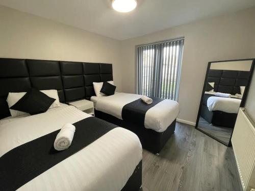 利物浦RYAN I AIR I BNB - 147-153 Mill Street - Free Parking的酒店客房,设有两张床和镜子