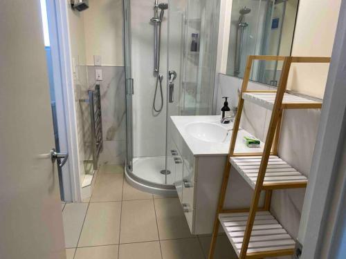 下哈特3 bed apartment with stunning harbour views的带淋浴和白色盥洗盆的浴室