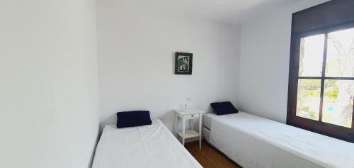 桑特费柳德吉克索尔斯COSTA BRAVA SUITES VILLA Cala Jonca的带窗户的客房内的两张床