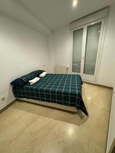 马德里Hotelly Atocha的一间卧室配有一张带绿色布艺毯子的床