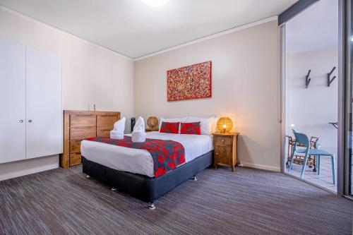 马库拉Absolute Beachfront Penthouse - Ramada Marcoola的卧室配有1张床、1张桌子和1把椅子