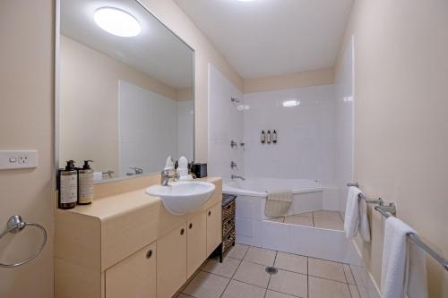 马库拉Absolute Beachfront Penthouse - Ramada Marcoola的一间带水槽、浴缸和卫生间的浴室