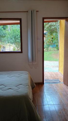 卡西米鲁-迪阿布雷乌Pousada Casa da montanha的一间卧室设有一张床和一个滑动玻璃门