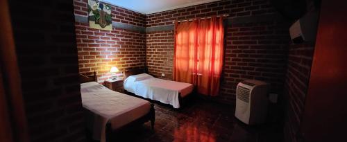 贝伦El Belichito的一间设有两张床和砖墙的房间