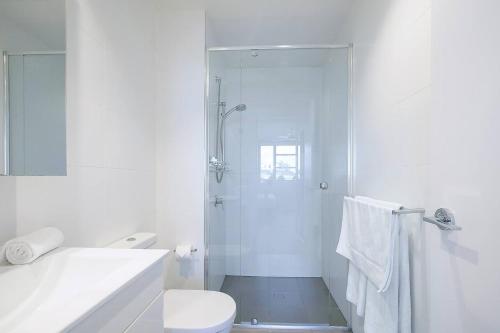 布里斯班Regatta Hideaway - A Breezy Balcony Residence的带淋浴和卫生间的白色浴室